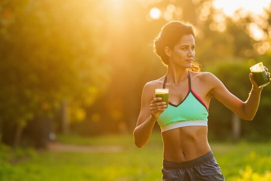 تصویر فردی با شکم صاف در حال ورزش و تغذیه سالم برای کاهش سایز شکم