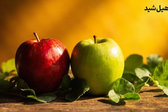 سیب قرمز و سبز تازه با برگ‌های سبز، نماد سلامت و تغذیه سالم
