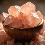 کریستال و پودر نمک صورتی هیمالیا در کاسه چوبی